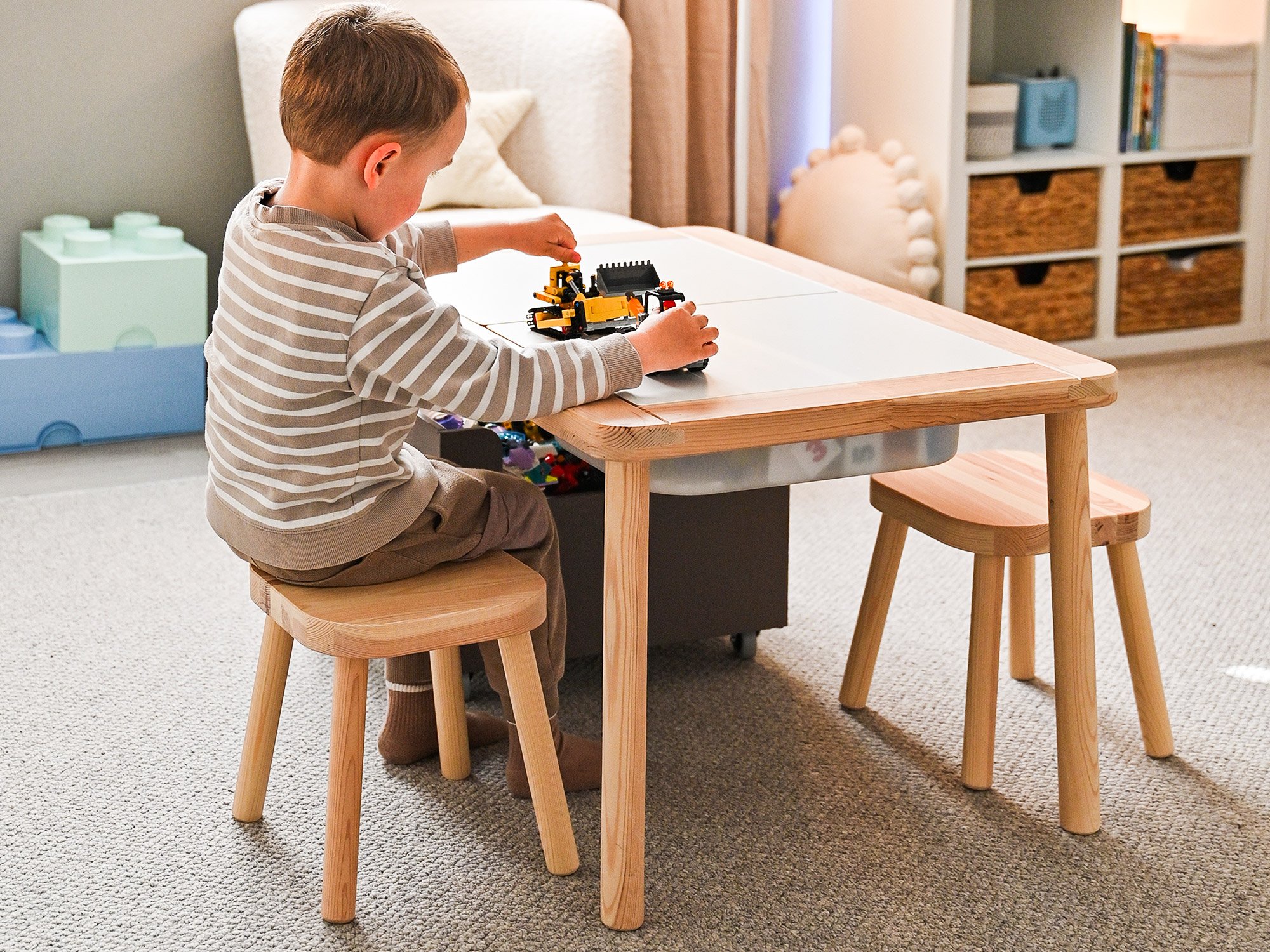 Der hellbeige Wollteppich Tetouan als Rechteck liegt in einem Kinderzimmer während ein kleiner Junge auf ihm spielt