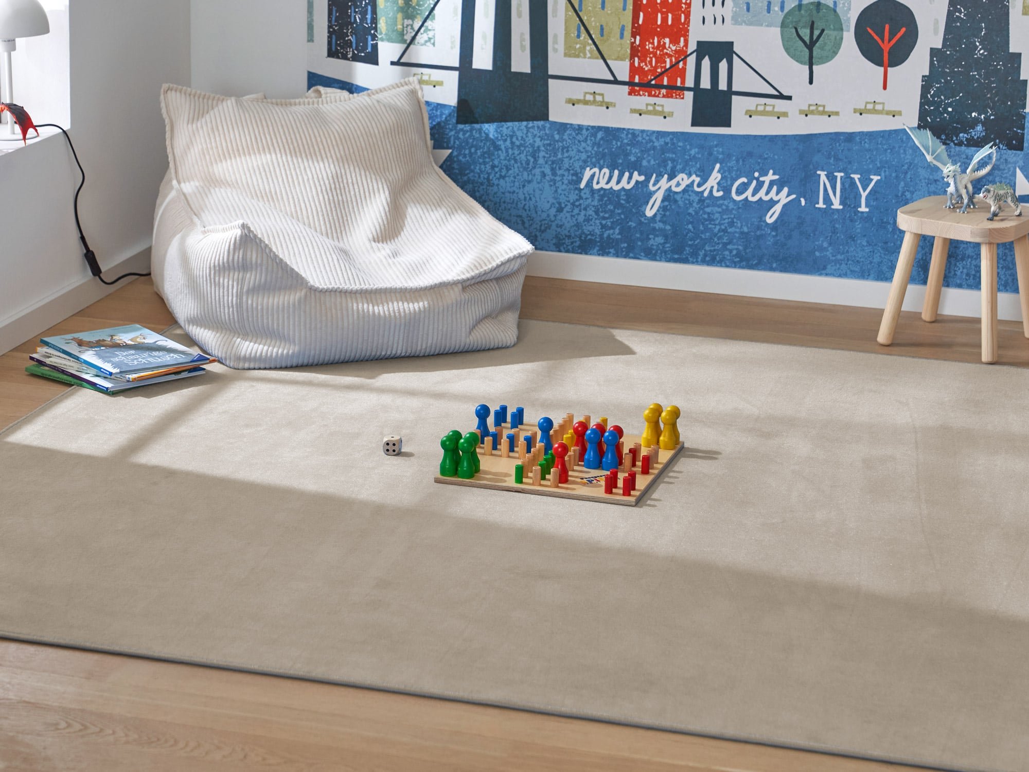 Der beige Kurzflorteppich Mauro Uni in der Form eines Rechtecks liegt in einem Kinderzimmer